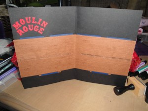 The inside of the Moulin Rouge card with the 'letterbox' cut-outs for the luggage tags to go into